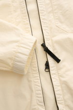Close-up front view of the Stone Island Blouson 'Stretch Cotton Twill-TC' creme, showing elastic cuffs and robust two-way zipper. Sportives Frühlings-Essential: light elastic cotton, soft touch, slim fit, garment dyed, hood with drawstring, chest and side
