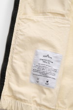 Close-up inside view of the Stone Island Blouson 'Stretch Cotton Twill-TC' creme showing the inner pocket and fabric label with garment dyed, anti-drop finish, elastic cuffs, slim fit features. Sportives Frühlings-Essential: Mit seinem leichten Baumwollma