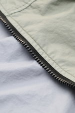 Nahaufnahme der Stone Island Jacke 'Membrana' salbei mit Reißverschluss, dreilagigem, wind- und wasserabweisendem Funktionsgewebe.