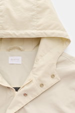Close-up von Kapuze und Kragen des 04651/ A trip in a bag Parka 'The Coat' sand aus hochwertiger Microfaser mit Reißverschluss, Windblende und Tunnelzug.