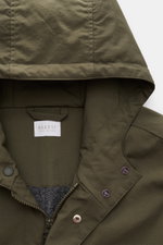 Detailaufnahme von Kapuze und Kragen des olivfarbenen 04651/ A trip in a bag Parka 'The Coat' mit Reißverschluss, Knöpfen und hochwertiger Microfaser.