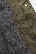 Nahaufnahme des innenliegenden grauen Futterstoffs und des Reißverschlusses des 04651/ A trip in a bag Parka 'The Coat' oliv mit hochwertiger Microfaser.