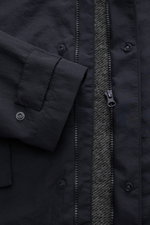 Close-up front view of the 04651/ A trip in a bag Jacket dark navy, showing high-quality microfibre, smooth feel, lightweight padding, wind and water repellent, regular fit, zip, concealed hood, raglan sleeves, hip pockets with flap, woven label, snap but