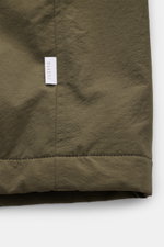 Nahaufnahme der unteren Kante der 04651/ A trip in a bag Jacke oliv mit hochwertiger Microfaser, glattem Griff, wattiert, wind- und wasserabweisend.