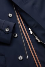 Close-up top-down view of the Mandelli Jacke navy showing navy pure wool fabric, buttons with "Mandelli" engraving, two-way zipper with tan trim, and buttoned cuffs, highlighting timeless elegance and refined details for transitional season style. <p>Zeit