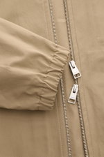 Nahaufnahme des Ami Paris Blouson taupe von oben auf den elastischen Ärmelbündchen und den zwei-Wege-Reißverschluss aus reiner Baumwolle.