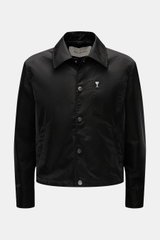 Frontale Aufnahme der Ami Paris Jacke schwarz aus hochwertiger Microfaser, Regular Fit, mit Druckknopfleiste, Umlegekragen, Logo, Fronttaschen und Knopfärmeln.