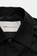 Schwarzer Umlegekragen der Ami Paris Jacke schwarz aus Microfaser, glatter Griff, Druckknopf an der Front, Detailfoto von vorne oben.