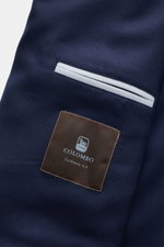 Nahaufnahme der Colombo Cashmere Jacke navy von COLOMBO, Detailansicht der paspelierten Fronttasche und des Logos aus reiner Cashmere-Qualität.