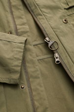 Close-up front view of the Barbour Field jacket 'Sanderling' olive, showing zipper, snap buttons, and fabric texture, lightweight cotton blend.