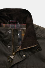 Barbour Wachsjacke 'Sander' dark olive, Detailansicht Kragen mit Cordbesatz, karierter Innenfutterstoff, Reißverschluss und Druckknöpfe.