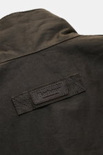 Nahaufnahme der Rückseite der Barbour Wachsjacke 'Sander' dark olive mit gewachster Baumwolle und sichtbarem Leder-Logo.