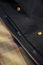 Barbour Parka 'Icons Border' dark navy Detailaufnahme von Reißverschluss, Druckknöpfen und Tartan-Innenfutter, Baumwoll-Microfaser-Mix, Regular Fit.