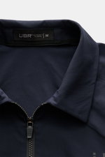 Nahaufnahme der UBR Jacke 'Nano' navy aus glatter Microfaser, slim fit mit Umlegekragen, Zwei-Wege-Reißverschluss und Reflektor-Details.