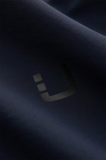 UBR Blouson 'Delta' navy aus hochwertiger Microfaser, Detailaufnahme des glatten Stoffes mit Logo, schräg fotografiert.