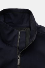 Close-up front view of the UBR Blouson 'Bullet Savile' navy showing the standing collar and partially zipped high-closing two-way zipper, made from fine wool and microfibre twill. Minimalist and functional: With its ultra lightweight design and the fine w