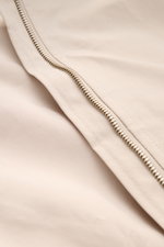 Nahaufnahme des robusten Reißverschlusses am beigefarbenen 04651/ A trip in a bag Blouson 'Peached Cotton' aus Baumwolle-Microfaser-Mix.