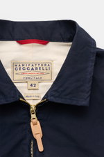 Nahaufnahme der Manifattura Ceccarelli Wachsjacke 'Blazer Coat' navy aus paraffinierter, wasserabweisender Baumwolle, mit Umlegekragen und robustem Zwei-Wege-Reißverschluss, fotografiert von vorne oben.