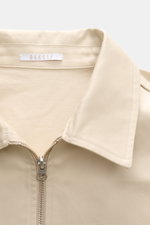 Nahaufnahme des beigen 04651/ A trip in a bag Blouson 'Griffin' mit Umlegekragen, robustem Reißverschluss und feiner Baumwollqualität.