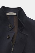Nahaufnahme der Corneliani Wolljacke navy von oben fotografiert, reine Schurwolle, strukturierter Griff, Slim Fit, Stehkragen mit Knopf, Vier-Knopf-Leiste, robuster Zwei-Wege-Reißverschluss, aufgesetzte Brust- und Hüfttaschen, Unconstructed Design, eine I