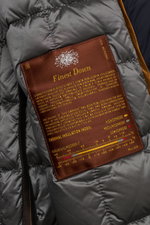 Close-up view of the interior label of Moorer Down parka 'Vannes' dark navy, showing finest down filling and smooth lining. Features: outer material made of premium quality microfibre, smooth feel, water repellent, warm down lining, detachable double fron