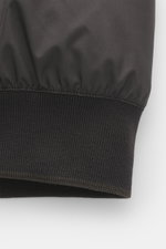 Close-up side view of the ribbed cuff with contrast edges on the Moorer Down blouson 'Oniro' dark brown, made of high-quality microfiber with a soft touch, light down filling, and water-repellent finish, featuring a slim fit, two-way zipper, hood with dra