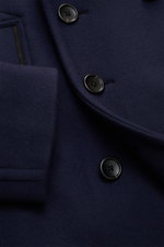 Nahaufnahme der Tom Ford Cabanjacke navy aus reiner Wolle, Slim Fit, mit zweireihiger Drei-Knopf-Leiste und Leder-Details an Kragen und Taschen.