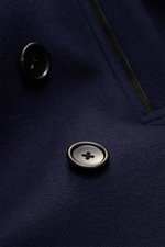 Nahaufnahme der Tom Ford Cabanjacke navy aus reiner Wolle, Detail der zweireihigen Knopfleiste und Lederbesatzes, weicher Griff.