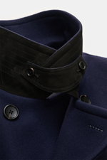 Nahaufnahme der Tom Ford Cabanjacke navy aus reiner Wolle, detailreich von oben fotografiert, zeigt Slim Fit, breiten Reverskragen mit Leder-Detail und Zwei-Knopf-Leiste.