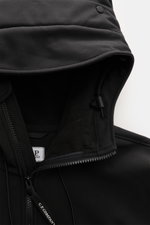 Nahaufnahme der Kapuze und des Reißverschlusses der C.P. Company Softshell-Jacke 'C.P. Shell-R Goggle Jacket' schwarz, Softshell aus recycelter Microfaser, wind- und wasserabweisend, atmungsaktiv, mit Goggle Lenses und Tunnelzug, weicher Griff, Slim Fit.