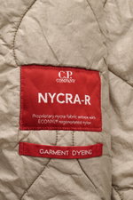 C.P. Company Blouson graugrün aus recycelter Microfaser, Slim Fit, stehend fotografiert, mit roten NYCRA-R-Labeln und elastischen Bündchen.