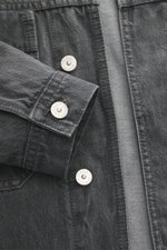 Stone Island Denim jacket 'Black Denim Light Grey Wash' grey shown close-up from the front, denim made from pure cotton with typical material structure, slim fit, concealed button placket, turn-down collar, patch chest pockets, piped front pockets, compas