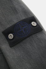 Close-up side view of the Stone Island Denim jacket 'Black Denim Light Grey Wash' grey, showing the compass badge on the upper arm, denim made from pure cotton with a typical material structure, slim fit, concealed button placket, turn-down collar, patch 