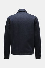 Back view of Stone Island Denim jacket 'Indigo Denim-Rinsed' dark blue, slim fit indigo-dyed cotton denim with typical fabric texture, turn-down collar, cuffs with button, and compass badge on upper sleeve.