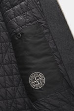 Close-up inside view of the Stone Island Jacke 'No Seasons Garment Dyed Crinkle Reps NY' graugrün showing quilted lining, inner pocket with Stone Island badge, and fabric details.