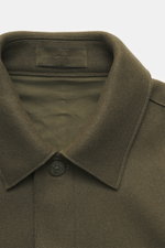 Close-up front view of Stone Island Jacket 'Panno Ghost Piece' olive, showing turn-down collar, five-button placket, textured mix of wool and microfiber, slim fit, patch chest pockets, front pockets with flap, tonal compass badge on sleeve, buttoned sleev