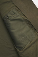 Stone Island Jacket 'Panno Ghost Piece' olive close-up from above showing front flap pockets, tonal compass badge, wool-microfiber blend, slim fit.