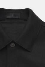 Close-up front view of Stone Island Jacket 'Panno Ghost Piece' black showing turn-down collar, five-button placket, patch chest pockets, front pockets with flap, tonal compass badge on sleeve, sleeve cuffs with snap button, slim fit, mix of wool and micro