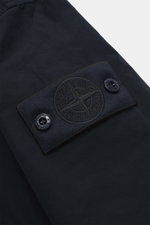 Stone Island Jacke 'David Light-TC Ghost Piece' navy im Detail, Nahaufnahme des tonalen Kompass-Badges aus hochwertiger Microfaser, Anti-Drop-Finish, samtiger Griff.
