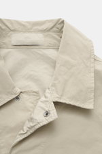 Close-up front view of Stone Island Jacket 'David Light-TC Ghost Piece' sand, made of high-quality microfiber with anti-drop finish, velvety feel, regular fit, concealed button placket, turn-down collar, slanted welt pockets with snap button, tonal compas
