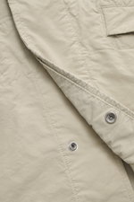 Close-up front angle of Stone Island Jacket 'David Light-TC Ghost Piece' sand showing high-quality microfiber, anti-drop finish, velvety feel, regular fit, concealed button placket, turn-down collar, slanted welt pockets with snap button, tonal compass ba