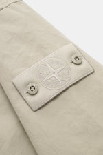 Close-up view of the tonal compass badge on the sleeve of the Stone Island Jacket 'David Light-TC Ghost Piece' sand, made from high-quality microfiber with anti-drop finish, velvety feel, regular fit, concealed button placket, turn-down collar, slanted we