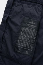 Nahaufnahme der Innenseite der Stone Island Jacke 'Nylon Smerigliato Ghost Piece' navy, mit schwarzem Label und Materialbeschreibung, ungefüttert, hauteigene Microfaser.