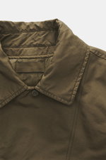 Nahaufnahme der Stone Island Jacke 'David-TC Ghost Piece' oliv, schräger Kragen und gestepptes Innenfutter aus weichem Microfaserstoff.