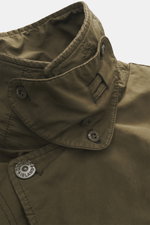 Nahaufnahme der Stone Island Jacke 'David-TC Ghost Piece' oliv, von schräg oben, mit hochgestelltem, variabel verstellbarem Kragen und sichtbaren Knöpfen.