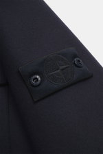 Nahaufnahme der Ärmelpartie der Stone Island Jacke 'Panno Ghost Piece' navy, Mix aus Wolle und Microfaser, strukturierte Haptik, Slim Fit, mit tonalem Kompass-Badge, Druckknopf am Ärmel, fotografiert von der Seite.
