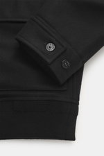 Close-up front view of the sleeve cuff of the Stone Island Blouson 'Wool Nylon Flannel Ghost Piece' black, featuring six-button placket, turn-down collar, tonal badge on upper arm, buttoned sleeve cuffs, mix of virgin wool and microfiber, soft feel, slim 