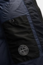 Close-up inside view of Stone Island Down jacket 'Garment Dyed Crinkle Reps NY' dark navy showing black inner pocket with logo button and compass badge, highlighting innovative coated crinkle microfibre fabric, lightweight and water repellent design with 