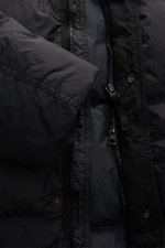 Stone Island Daunenjacke 'Garment Dyed Crinkle Reps NY' schwarz, Nahaufnahme von Reißverschluss und Daunenfüllung im Crinkle-Material.