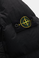 Nahaufnahme der Stone Island Daunenjacke 'Garment Dyed Crinkle Reps NY' schwarz mit Kompass-Badge, Crinkle-Microfaser und Resinbeschichtung, von schräg oben fotografiert.